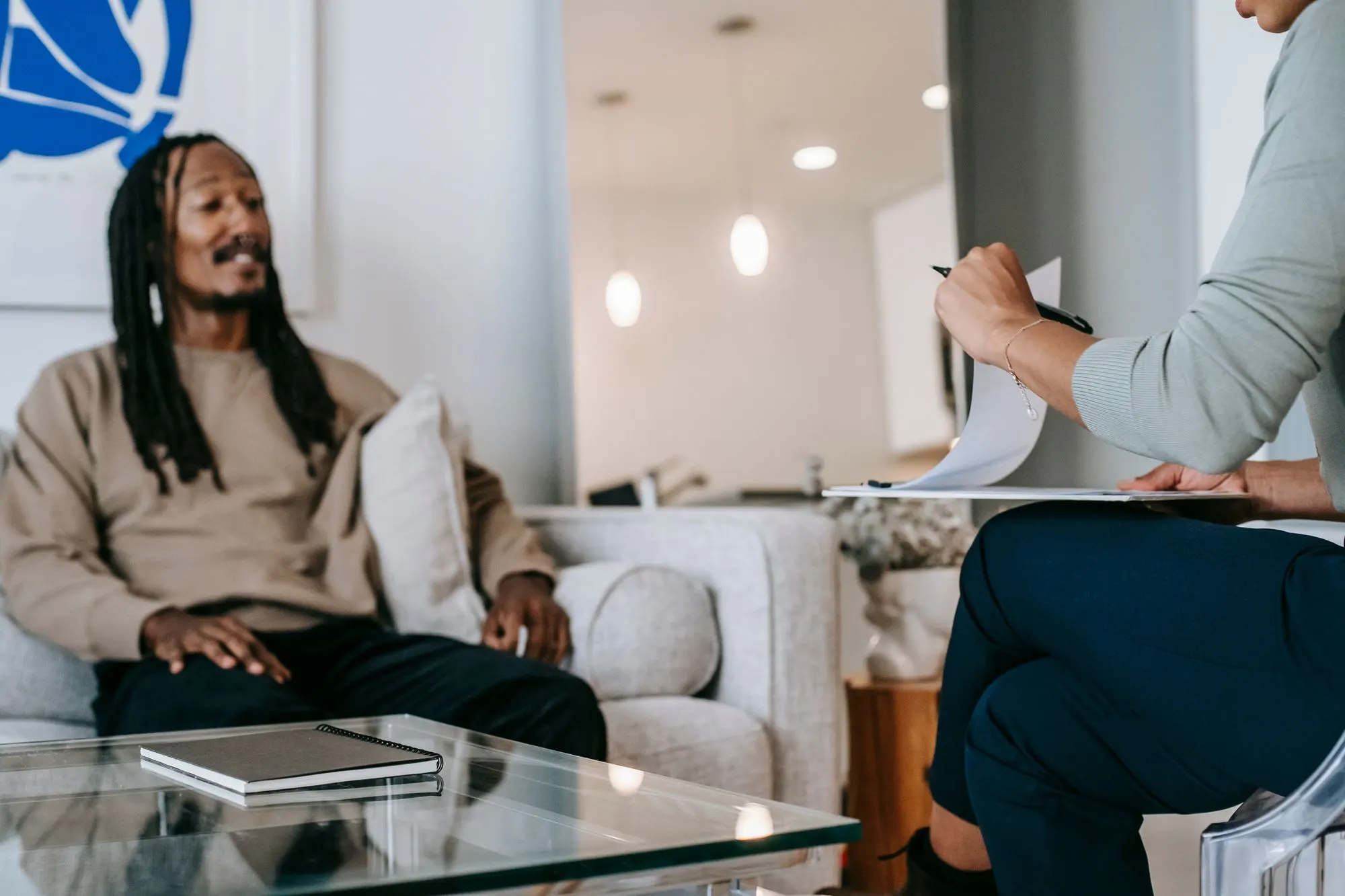 A client sitting on a sofa at the start of a therapy session