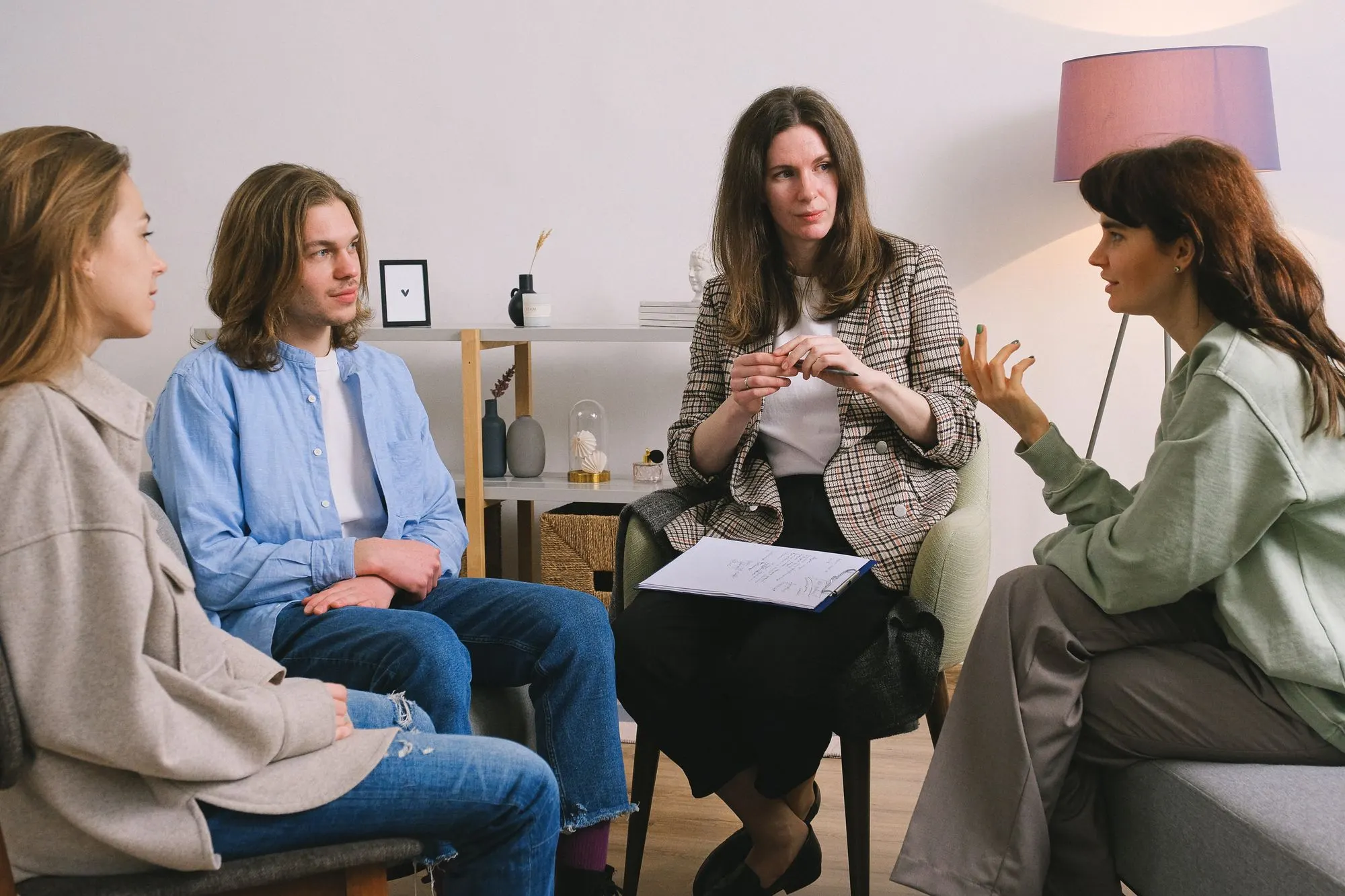 A small therapy group talking together in a bright, calm room